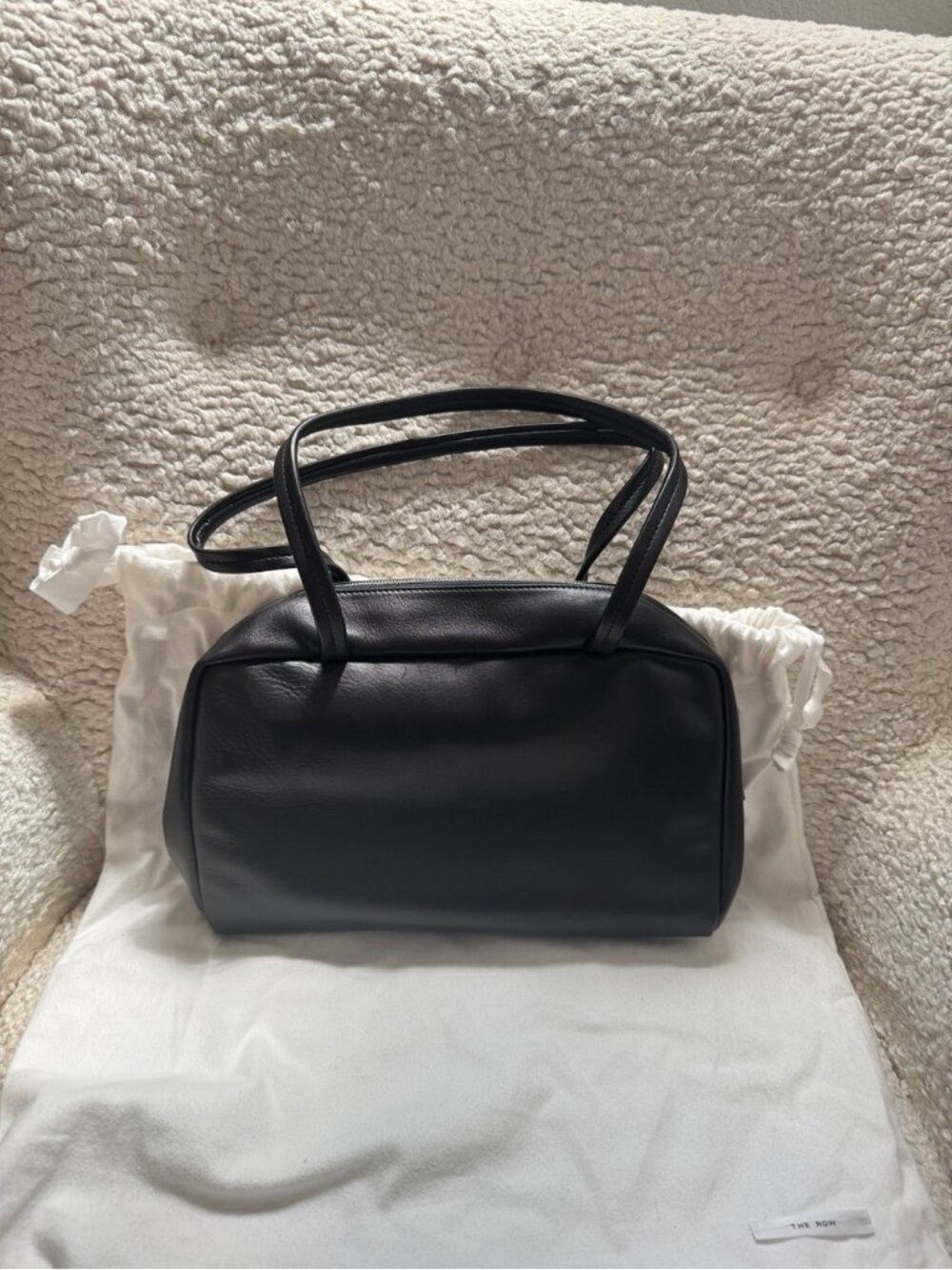 The Row Astra Black Leather Bowling Bag with Dual Handles and Zip Closure